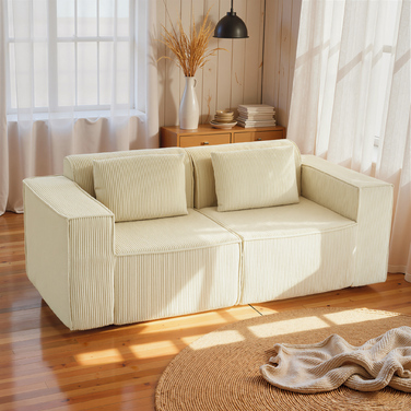 Диван на три особи, з м'якою пінопластовою структурою, широкими підлокітниками, двома подушками, обтягнутий тканиною з корду, бежевого кольору.